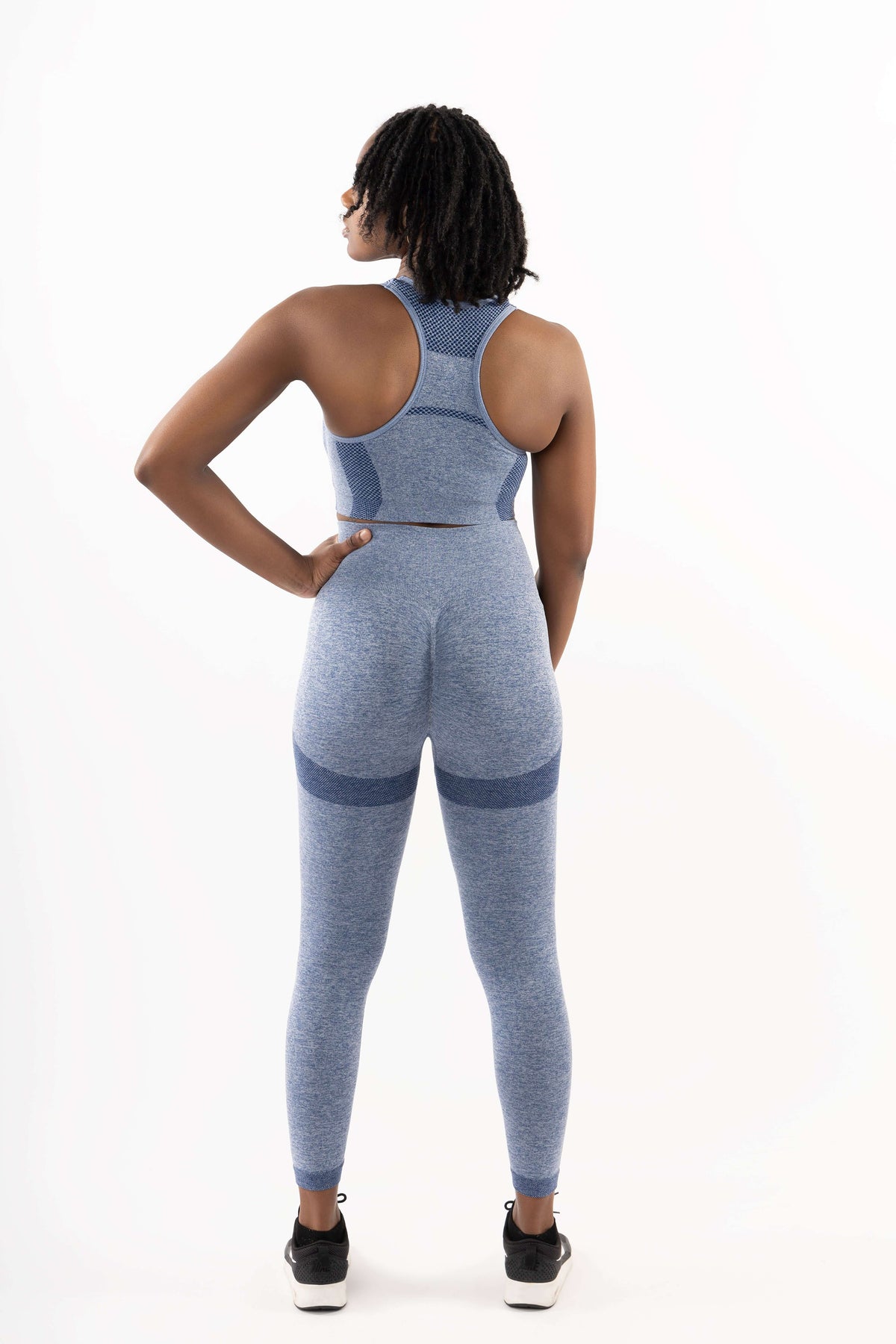 women in blue sleeveless gym set showcasing booty leggings and sports bra, perfect for fitness journeys.