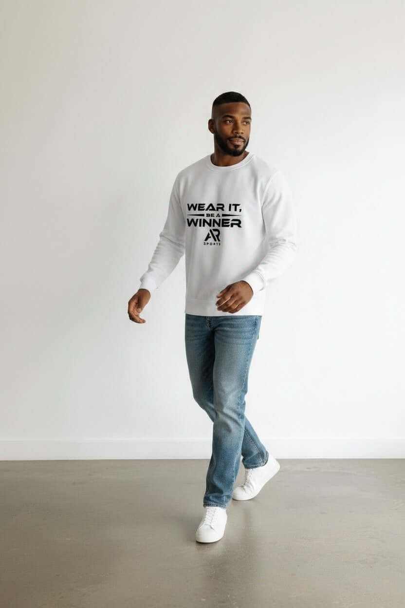 A man wearing a round neck sweater with the text 'WEAR IT, WINNER' walking in jeans and sneakers.