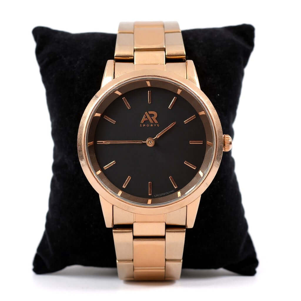 Wristwatch Timeless Rose Gold watch displayed on a black cushion, featuring a sleek black face and elegant design.