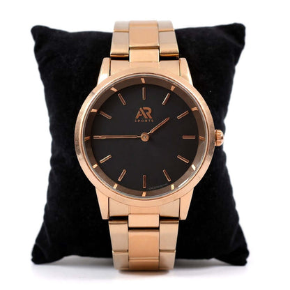 Wristwatch Timeless Rose Gold watch displayed on a black cushion, featuring a sleek black face and elegant design.